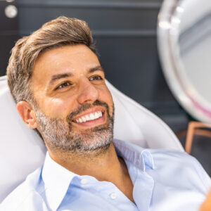 Middle aged man reviewing wrinkles in hand mirror after botulinum toxin