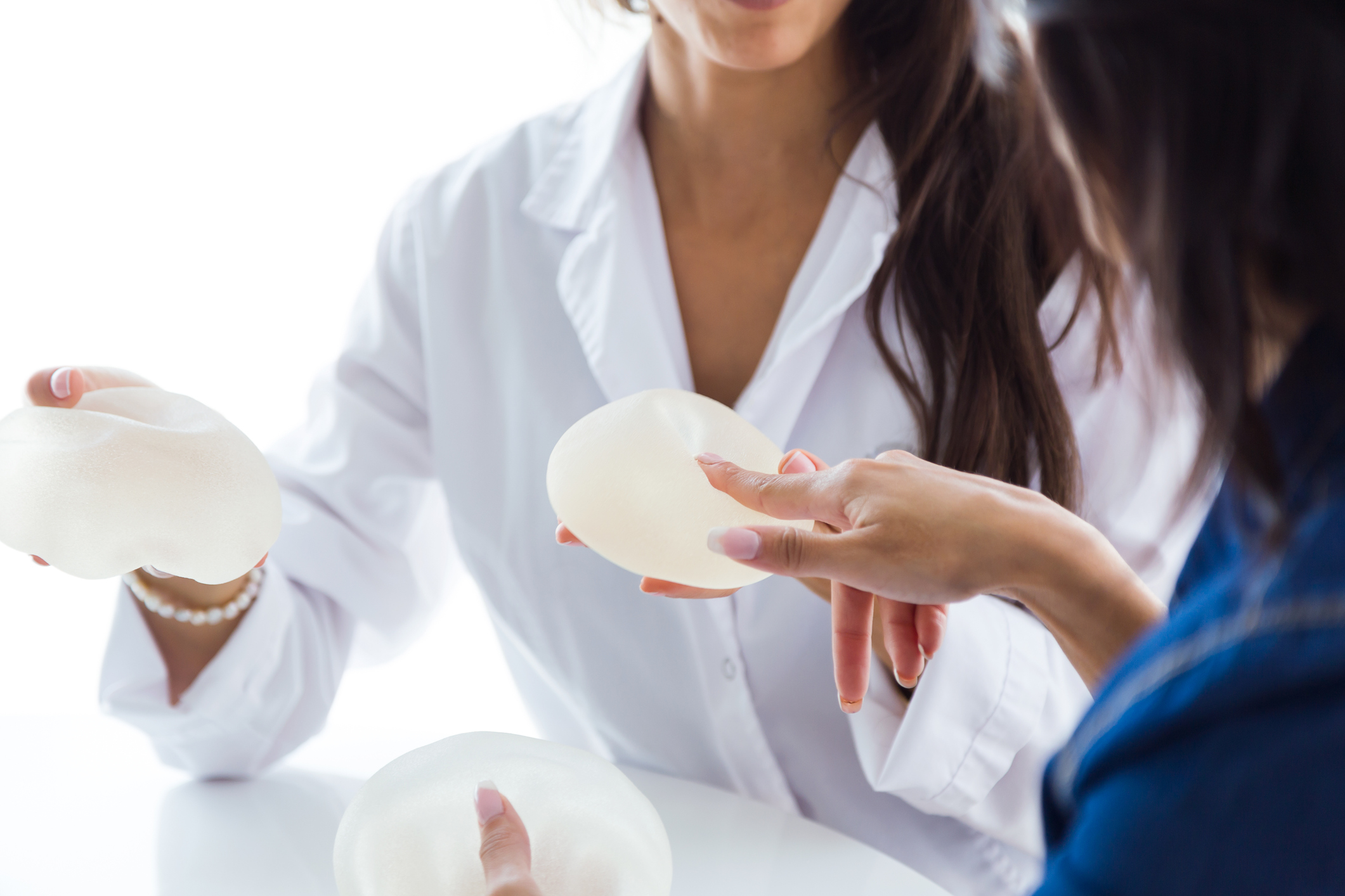 Doctor and her patient discussing silicone and saline breast implants