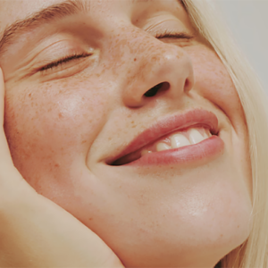 Blonde woman smiling - gender affirming facial feminization surgery blog post