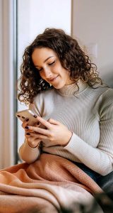 smiling woman looking at phone